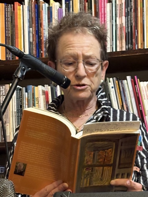Robin Becker reading in front of bookshelf at The Grolier Bookshop in Cambridge, MA